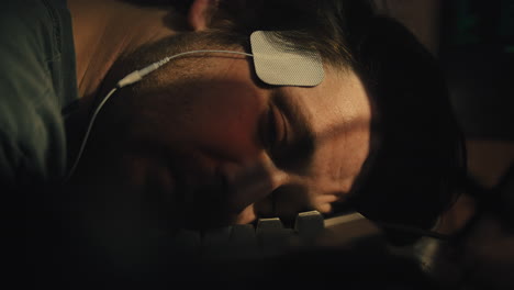 el hombre abre los ojos y se despierta con electrodos en la cabeza