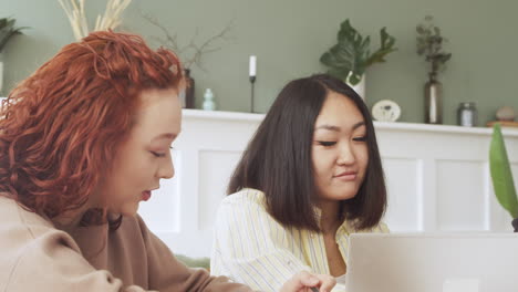 Lächelnd-Und-Debattierende-Frau-Beim-Betrachten-Des-Laptop-Computers-Während-Einer-Teambesprechung