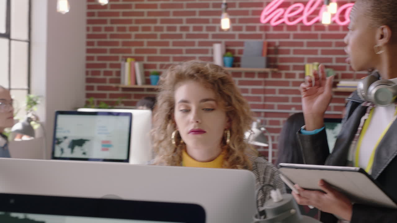 젊은 창의적인 사업가들이 아프리카계 미국인을 만나는 팀 리더 여성이 화면을 가리키며 아이디어를 공유하고 브레인스토밍을 하고 솔루션을 논의하고 컴퓨터를 사용하여 인턴을 훈련하고 현대적인 사무실에서 팀워크를합니다.