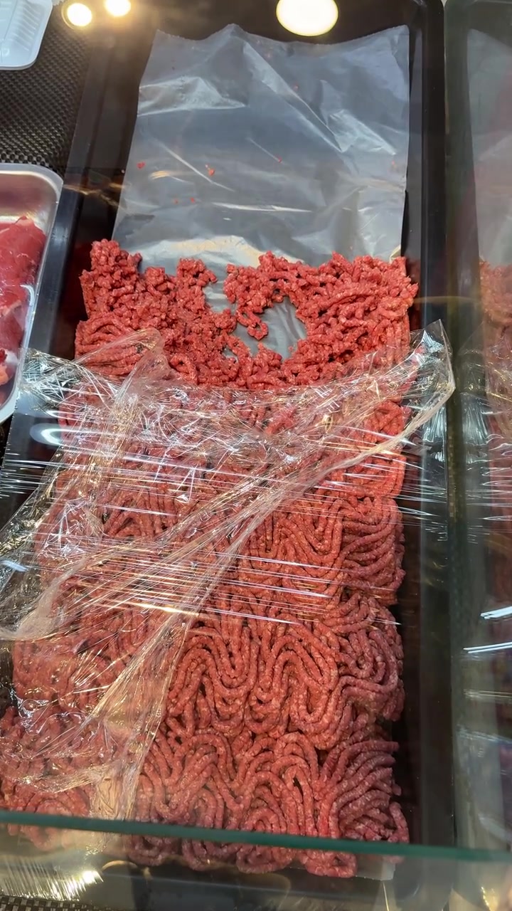 Hand Scooping Minced Meat at a Butcher Shop