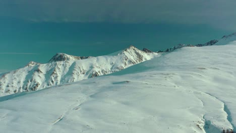 Antena:-Vista-Asombrosa-De-Los-Picos-De-Las-Montañas-Nevadas,-Paisaje-Invernal-Escénico-De-4k