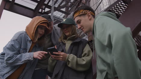 friens using smartphone outdoors