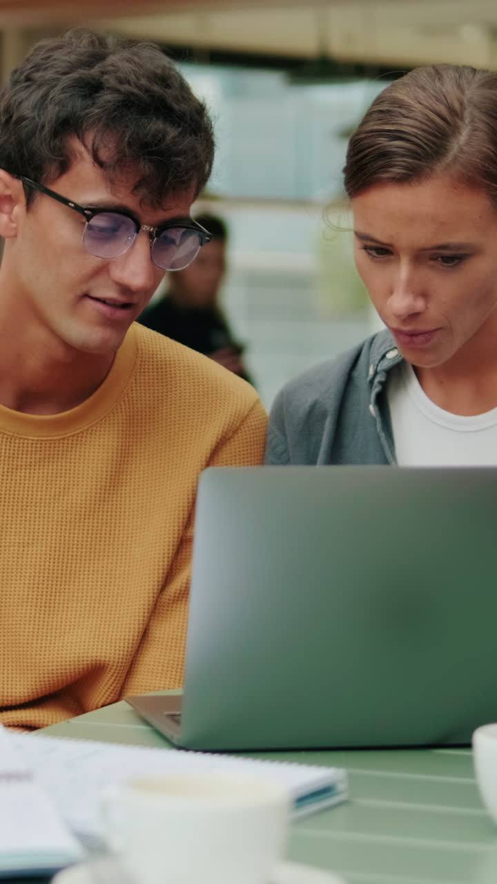 Students of different nationalities use modern technology outdoors, laptop for