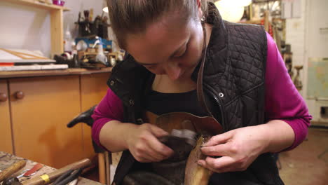 bespoke shoemaker pinning leather together to make shoe