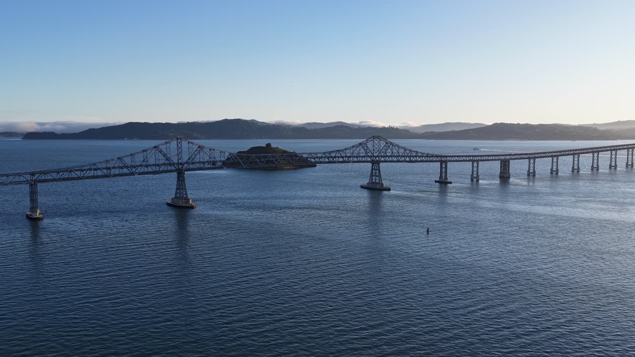 Splendide riprese aeree che mostrano il magnifico Ponte Richmond-San Rafael che collega due contee sulle calme acque blu della baia di San Francisco, con colline visibili sullo sfondo.