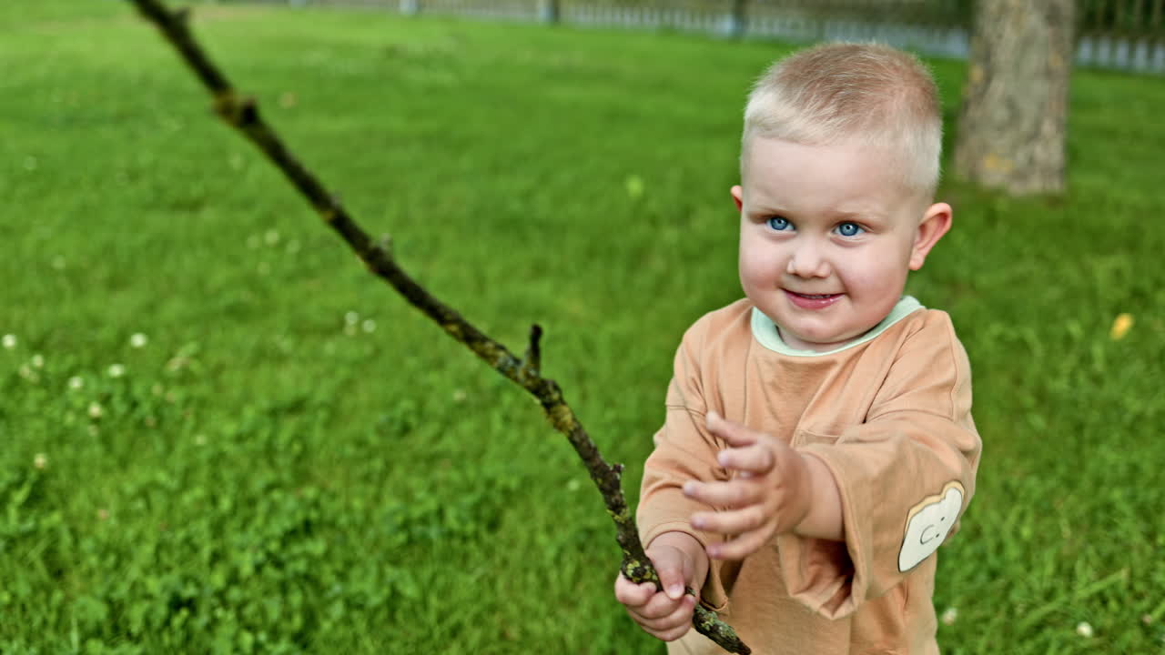 Bambino allegro che gioca all'aperto. Bambino piccolo che cammina fuori e gioca al parco giochi. Bambino che trascorre del tempo nella natura ed esplora il mondo intorno a sé