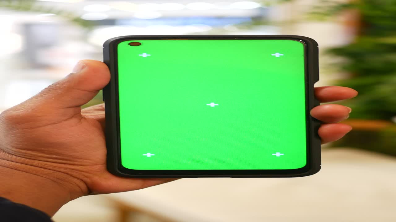 teléfono inteligente en la mano con pantalla verde