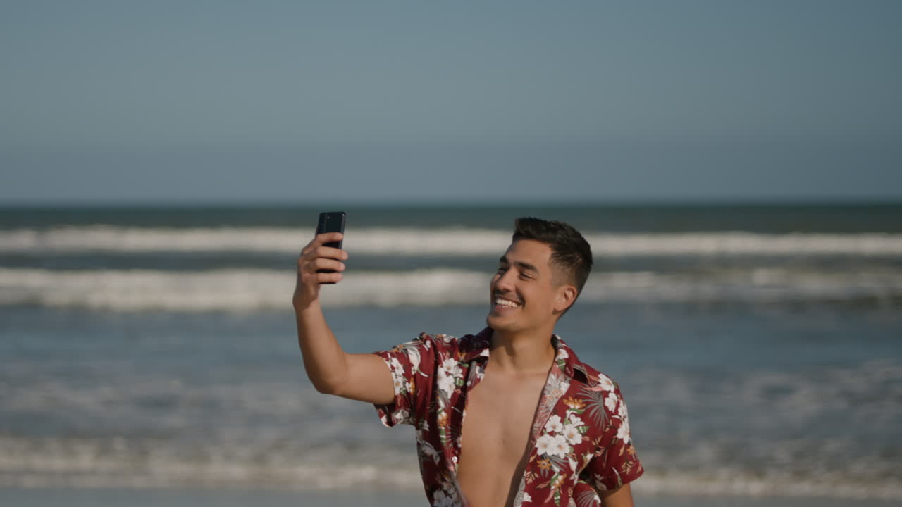 un tipo sonriendo en la playa.