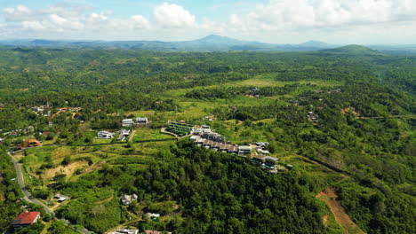 Aerial-drone-forward-moving-shot-over-developing-Kuta-Lombok,-Lombok-island-in-Indonesia-on-a-sunny-day