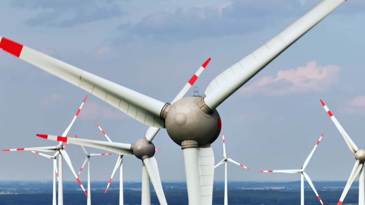 Aerial telezoom shot rotating in front of wind turbines at a eolic energy farm