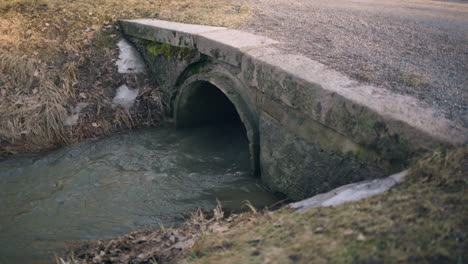 Langsame-Wanne-Mit-Wasser,-Das-Schnell-Aus-Dem-Steinernen-Abwassersystem-Im-Freien-Fließt