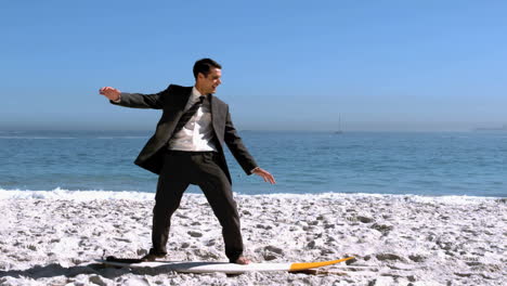 businessman balancing on surfboard on the beach