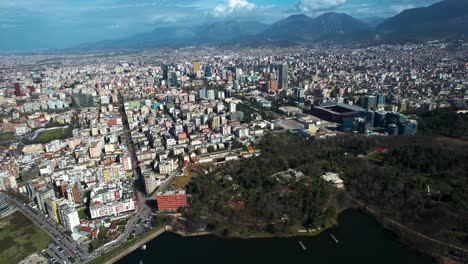 Reflexiones-Del-Paisaje-Urbano:-La-Vista-De-Tirana-Desde-El-Lago-Artificial,-Armonizando-El-Diseño-Urbano-Con-La-Serenidad-De-La-Vida-Frente-Al-Mar.