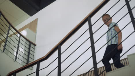 pupil walking downstairs inspecting school hall. boy standing stairway.