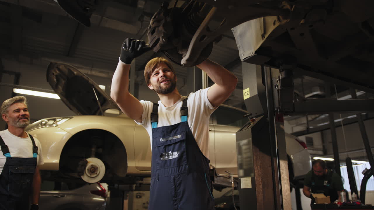 mecánicos de automóviles que trabajan en el tren de aterrizaje de un vehículo