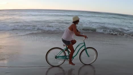 woman cycling at beach