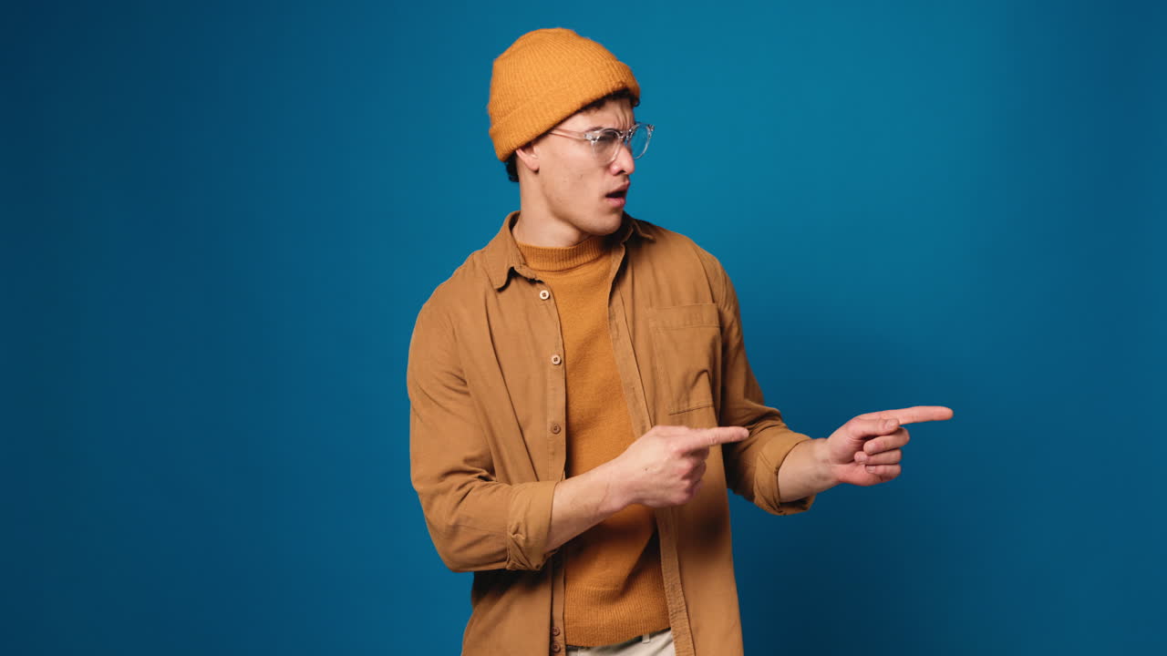 Man in brown shirt and hat with glasses