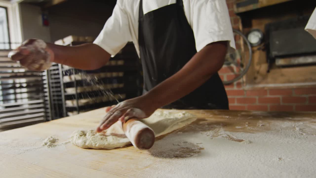 Animation of hands of diverse female and male bakers rolling sourdough for bread