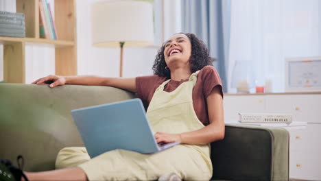mujer joven relajándose en el sofá y trabajando en la computadora portátil