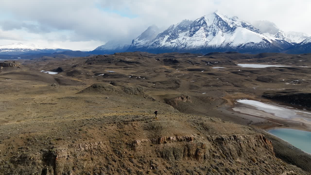Vista aerea con un escursionista solitario che esplora il vasto e aspro paesaggio di Torres del Paine nella Patagonia meridionale.