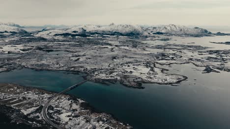 flesveien brua - flesveien bridge with snowy mountains from offersoykammen, leknes, norway. - aerial shot