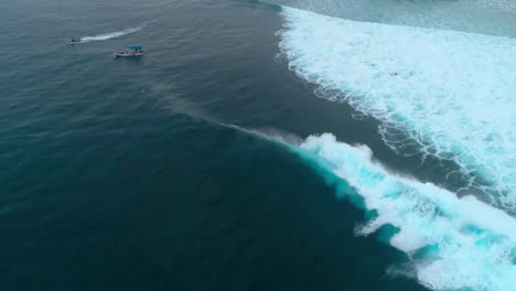 drone turns quickly to follow crashing wave erupting into whitewash at cloudbreak fiji