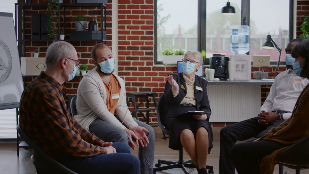 Person with face mask sharing anger management issues with group at aa meeting