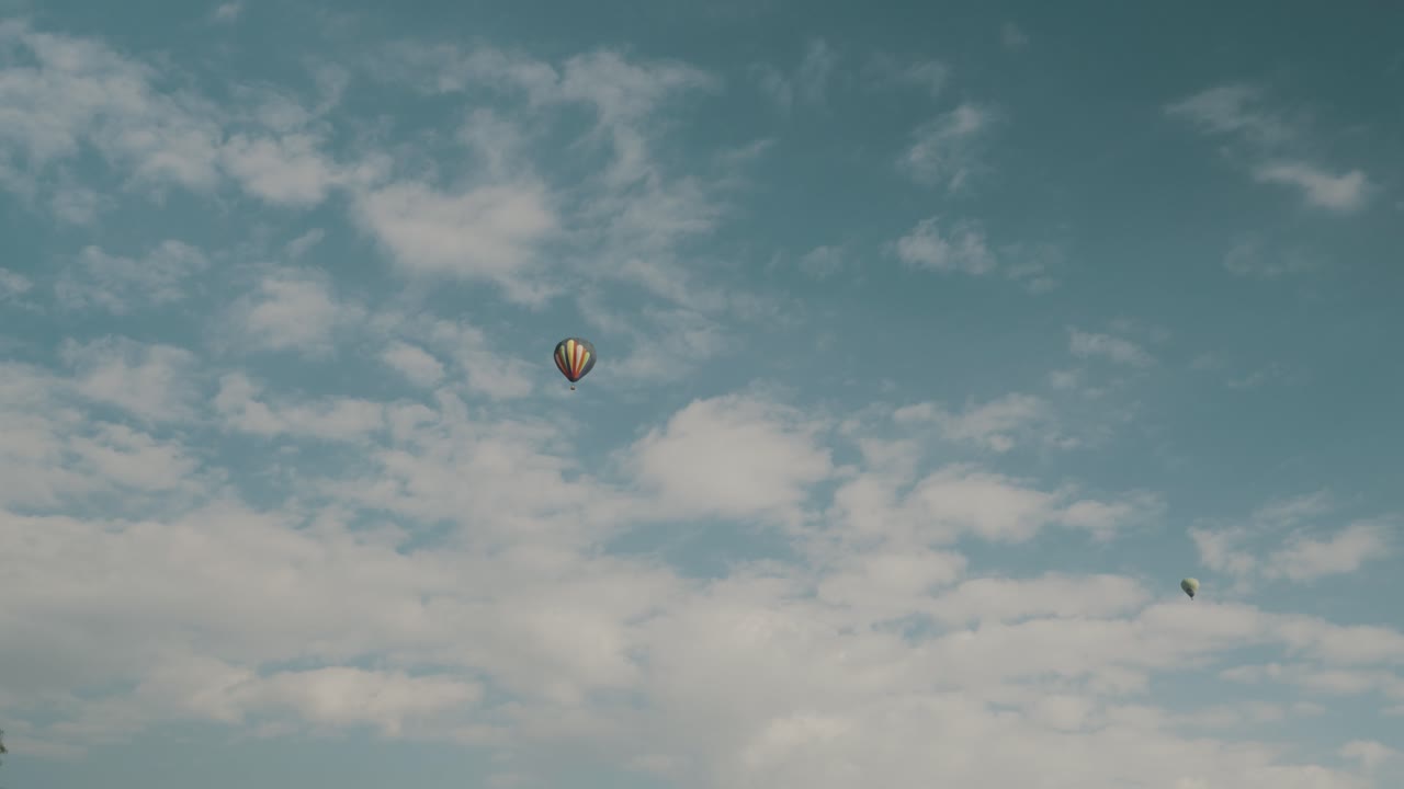 globos de aire caliente contra el cielo azul nublado en el sitio arqueológico de teotihuacan, méxico - tiro de ángulo bajo
