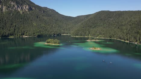 Gran-Lago-Con-Pequeñas-Islas-Diminutas-Playas-A-Lo-Largo-De-Donde-Los-Turistas-Viajan-En-Botes-Para-Relajarse-Y-Disfrutar-De-Este-Lugar-Tranquilo,-Una-Escapada-Perfecta-Cubierta-Por-Una-Naturaleza-Maravillosa-Y-Montañas-Lujosas