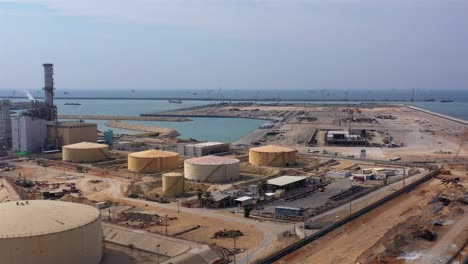 aerial footage over power plant with fuel tanks and chimneys, israel