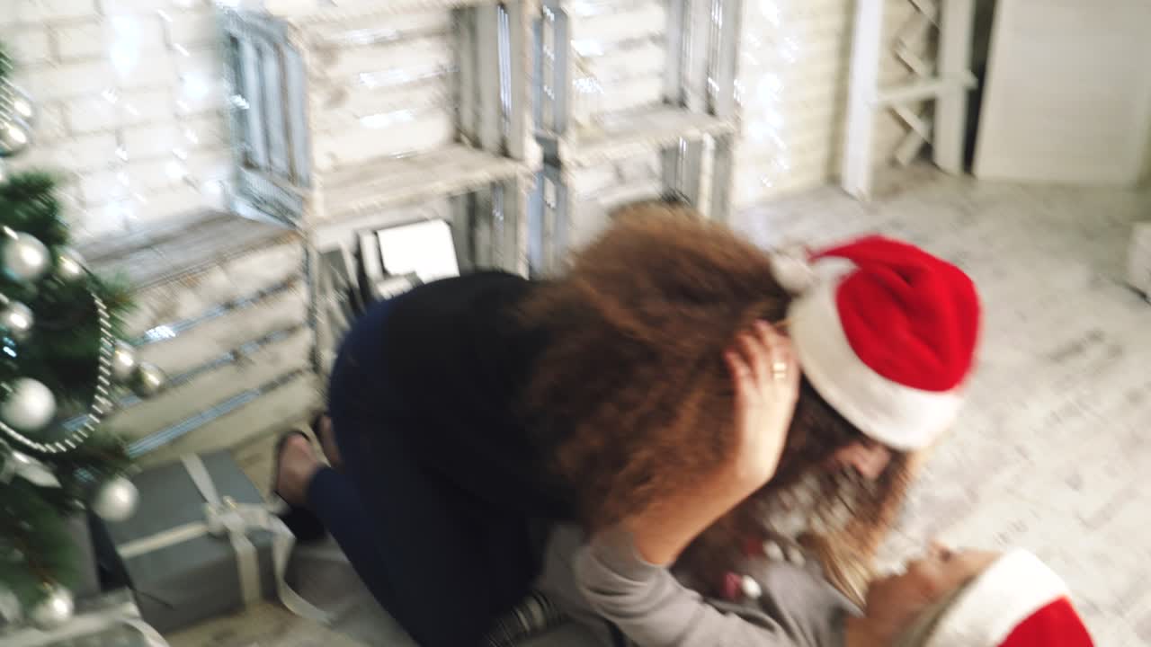 Women preparing Christmas tree. Beautiful girls sitting near the Christmas tree