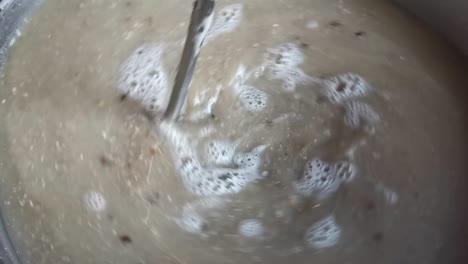 stirring the malt and water mixture during the mashing procedure of a home brewed pilsner