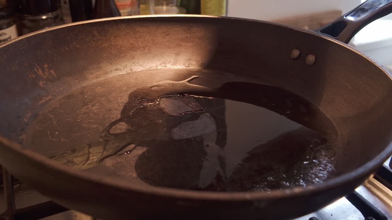Chef places mince beef into Hot frying pan of sizzling cooking oil CLOSE-UP