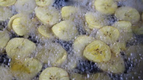 close up frying plantains in boiling oil