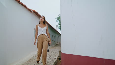 pretty tourist exploring village on european vacation. beautiful girl walking