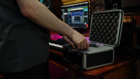 sound engineer takes out microphone from box. male hands taking out professional microphone at home recording music studio. digital audio workstation