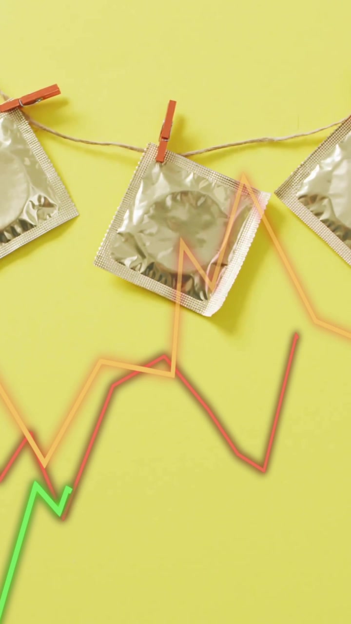 Preservativi appesi a una corda con mollette su animazione di grafico in crescita su sfondo giallo