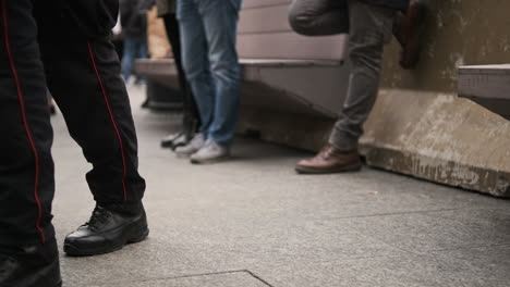 legs of carabinieri in milan italy, military police force wearing boots walking outside on a concrete floor