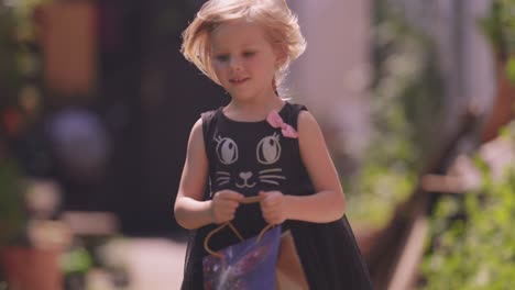 a young fair-haired girl runs joyfully holding a gift bag in her hands