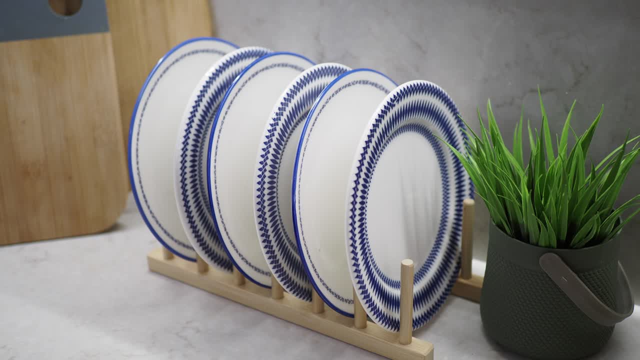 primer plano de una pila de placas azules y blancas en un estante de madera en una cocina