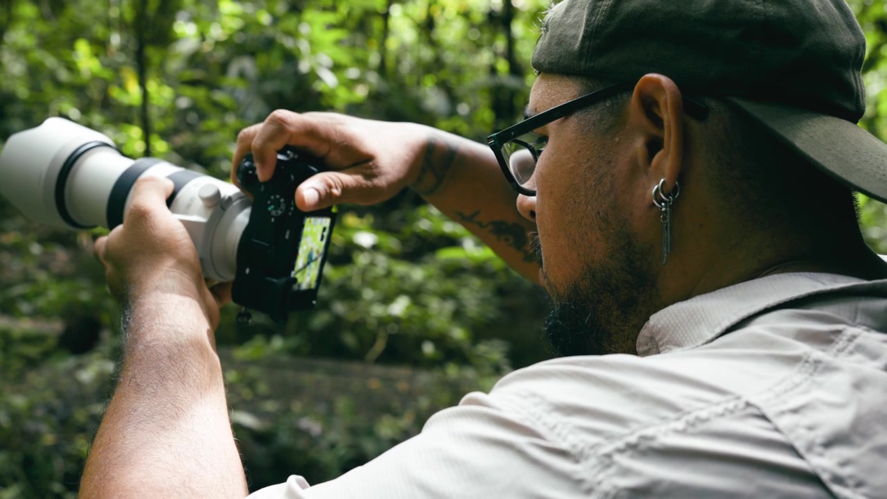 Fotografo con teleobiettivo in una foresta tropicale