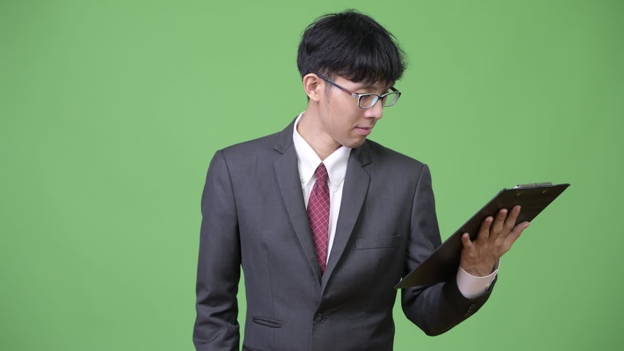 젊은 아시아 사업가 들 이 클립보드 를 사용 하여 읽고 생각 하고 있다