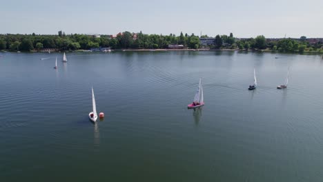 Veleros-Navegan-En-Un-Lago,-Tiro-Distante-De-Paralaje-De-Drones