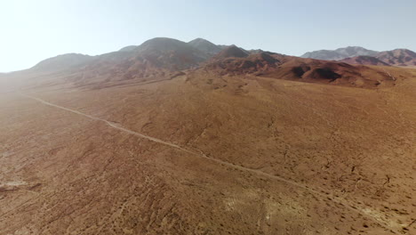 aerial shots of the barren, sandy, rocky, mountain filled, mojave desert on a sunny day