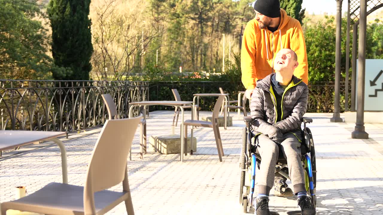 Man pushing woman in wheelchair outdoors