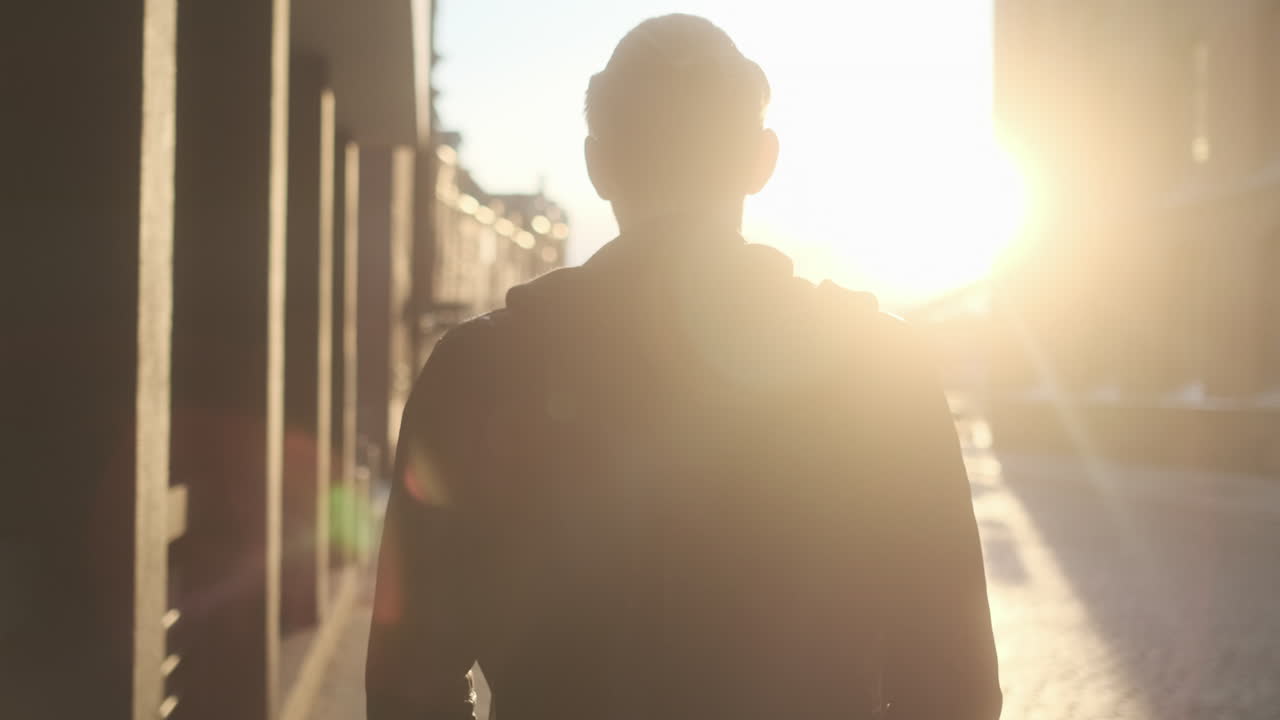 Young European Man with Glasses Walking Through City at Golden Hour with Black Clothes and Cars in Background (Hamburg, Germany)