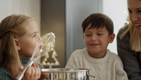 Video-Eines-Kleinen-Mädchens,-Das-Beim-Backen-Mit-Seinem-Bruder-Zuckerpaste-Probiert