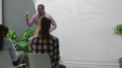 successful african american businesman celebrating team leader dancing funny excited colleagues using mobile technology sharing corporate victory on social media in lecture meeting