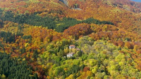 houses on a mountain slope covered with autumn foliage, aerial tilt up