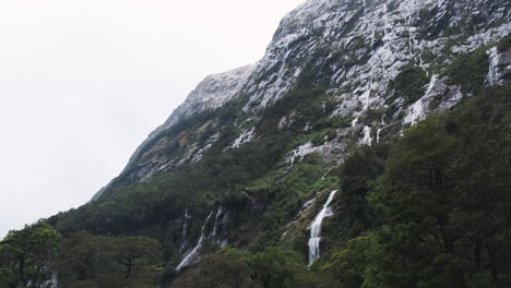 cascadas épicas que corren de las montañas del fiordo de la capa de nieve